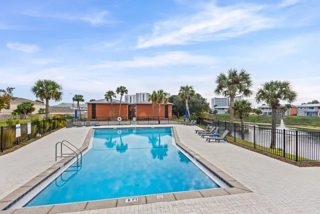 a view of a swimming pool with a patio and a ocean view
