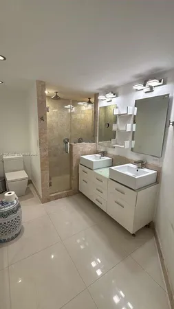 a bathroom with a double vanity sink toilet and shower