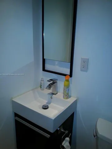 a bathroom with a sink toilet and a mirror