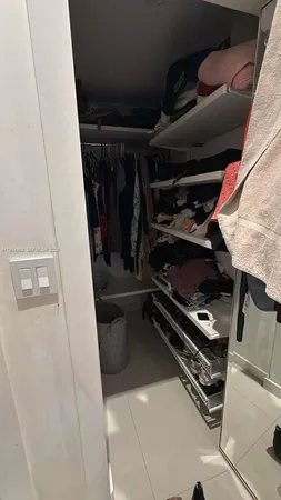 a view of walk in closet with clothes and shoes