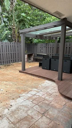 a view of backyard with wooden fence and large trees