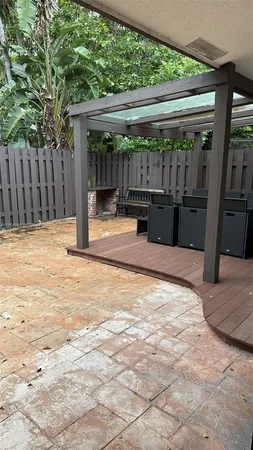 a view of backyard with wooden fence and large trees