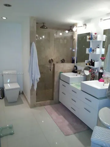 a bathroom with a double vanity sink mirror and toilet