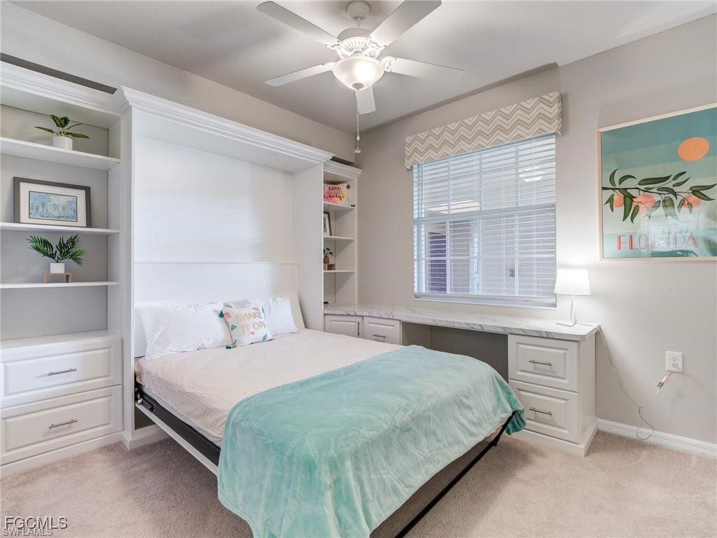 10711 Palazzo Way, Unit 203 Fort Myers, FL 33913 - Photo 11 of 24 a bedroom with a bed and a chandelier