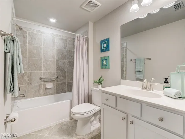 a bathroom with a bathtub shower sink vanity mirror and toilet
