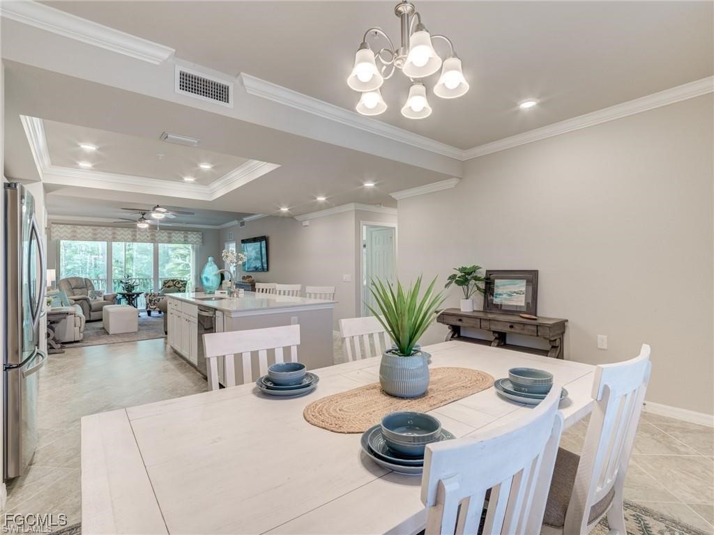 10711 Palazzo Way, Unit 203 Fort Myers, FL 33913 - Photo 4 of 24 a view of a dining room with furniture a livingroom and chandelier