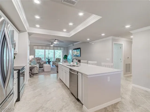 a large white kitchen with a large window and stainless steel appliances