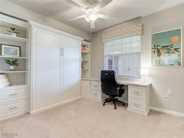 a view of a workspace with furniture and a window