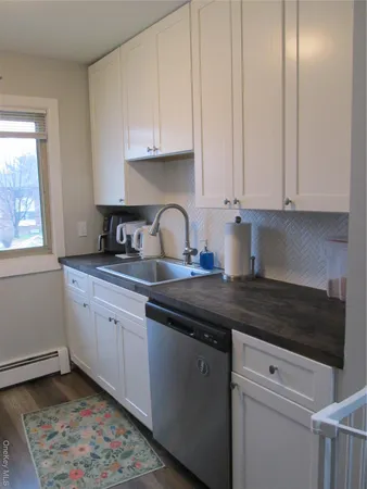 a kitchen with granite countertop a sink a stove and cabinets