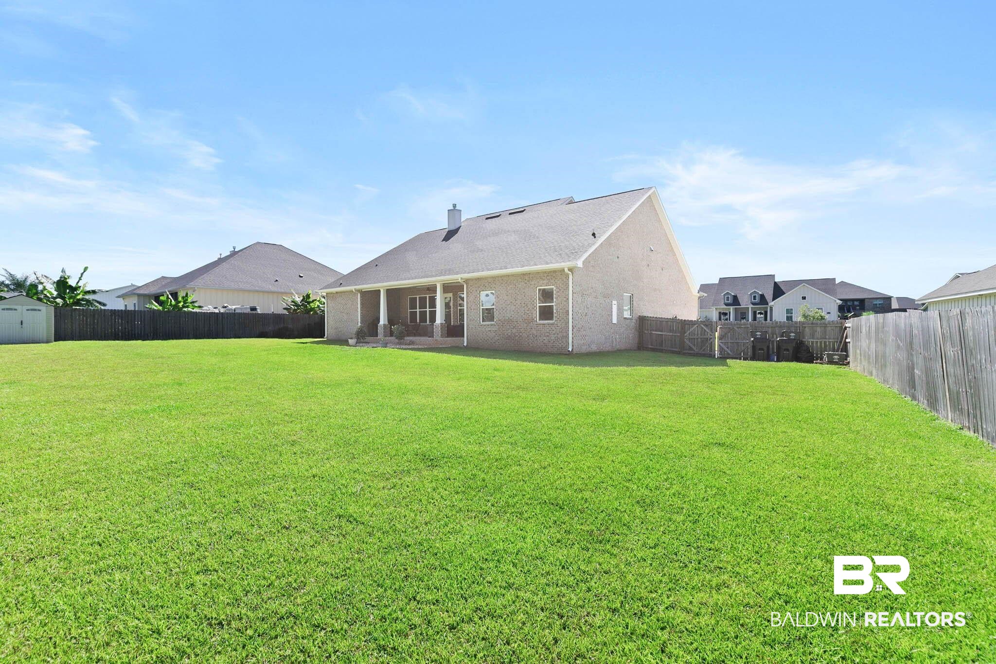 12785 Warbler Street Daphne, AL 36527 - Photo 47 of 53 Back of house with a patio area, a fenced backyard, brick siding, and a chimney