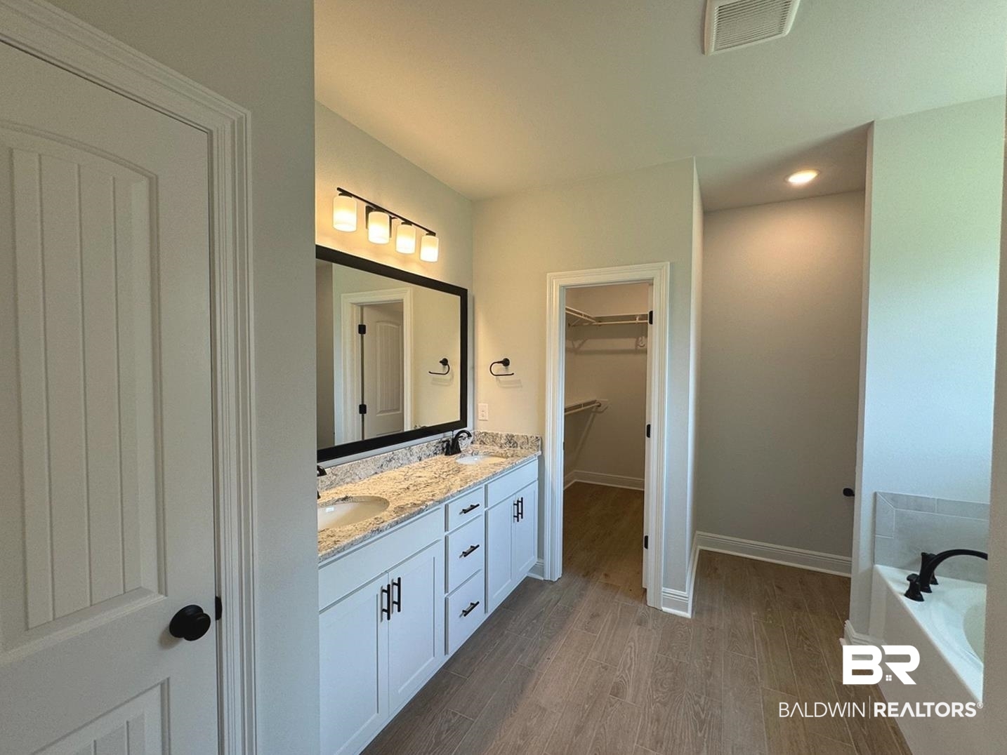 860 Sumter Loop Foley, AL 36535 - Photo 13 of 26 Bathroom with dual vanity, hardwood / wood-style floors, and a bathing tub