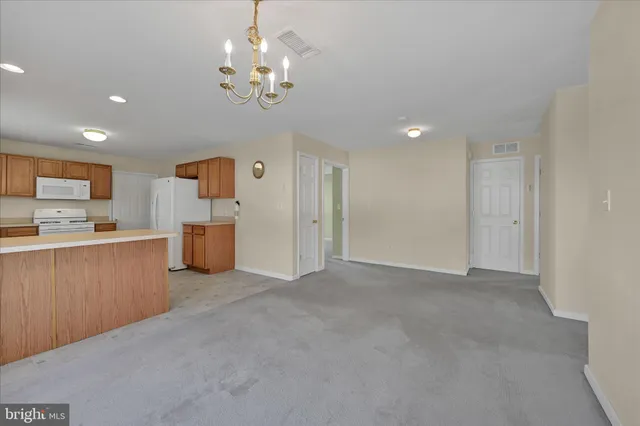 a view of a kitchen with a refrigerator a microwave and a sink