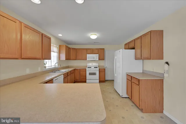 a kitchen with granite countertop a sink a counter top space stainless steel appliances and cabinets