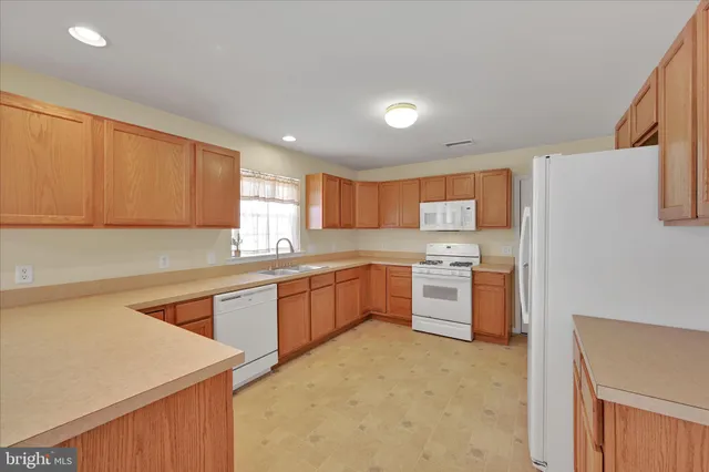 a kitchen with stainless steel appliances granite countertop a sink dishwasher stove and refrigerator