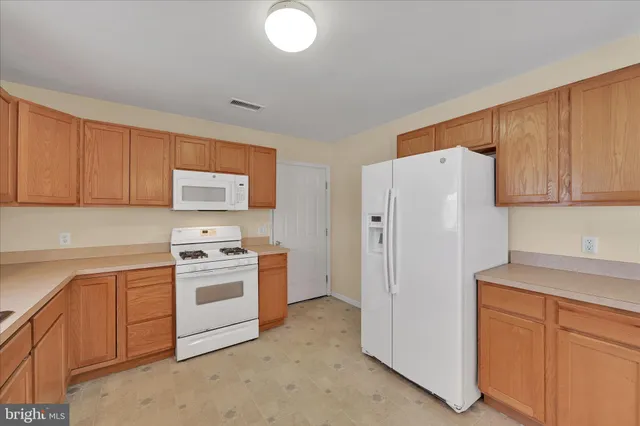 a kitchen with white cabinets and white appliances