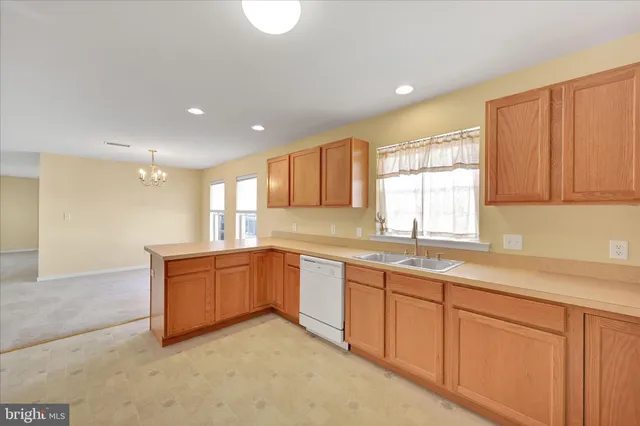 a large kitchen with kitchen island granite countertop a sink window and cabinets