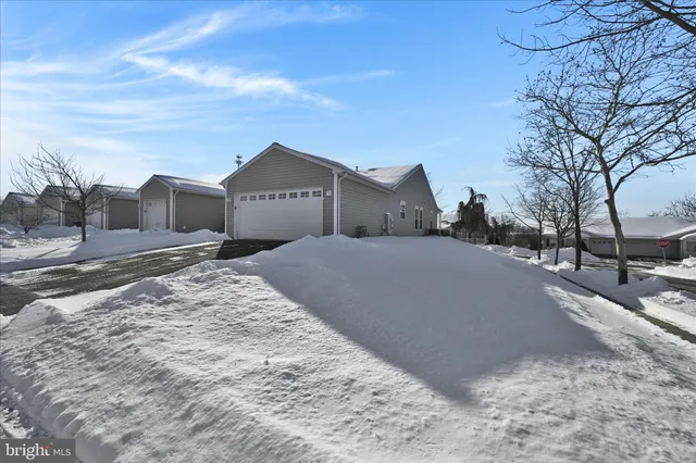 a view of a house with a yard covered in snow