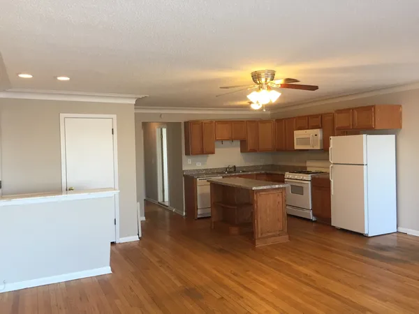 a kitchen with a refrigerator and a stove top oven
