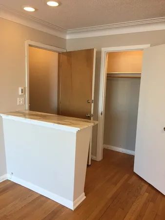 an empty room with wooden floor and entrance