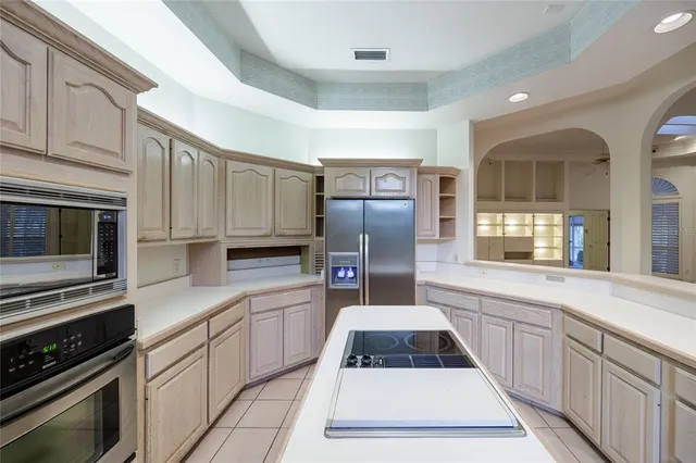 a view of an empty room and chandelier fan