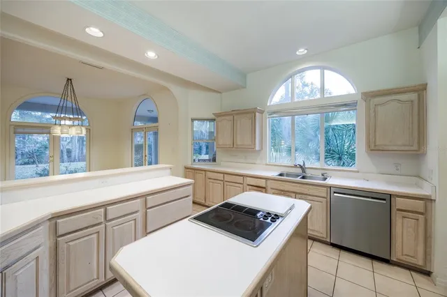 a view of an empty room with window and chandelier fan