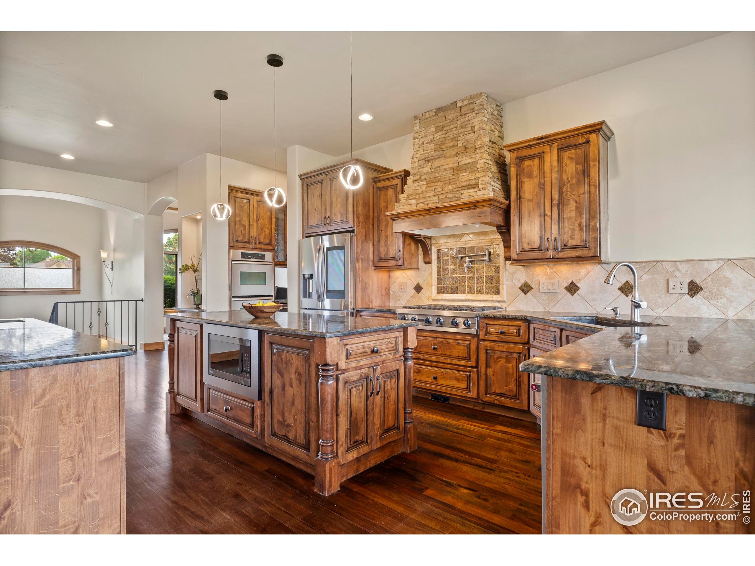 863 Riparian Way Fort Collins, CO 80524 - Photo 13 of 38 a kitchen with stainless steel appliances granite countertop a sink stove and refrigerator