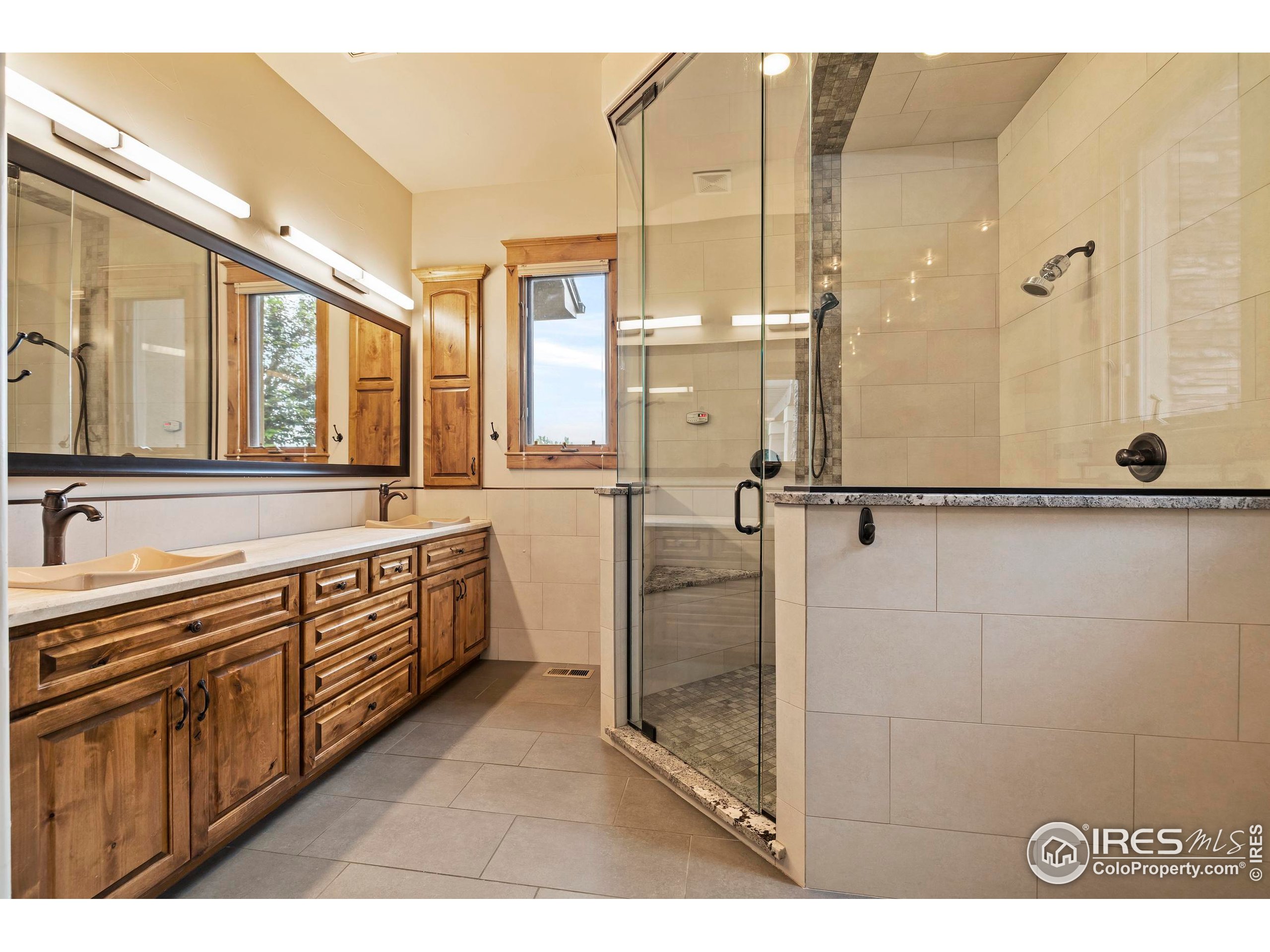 863 Riparian Way Fort Collins, CO 80524 - Photo 21 of 38 a bathroom with a double vanity sink a mirror and a shower