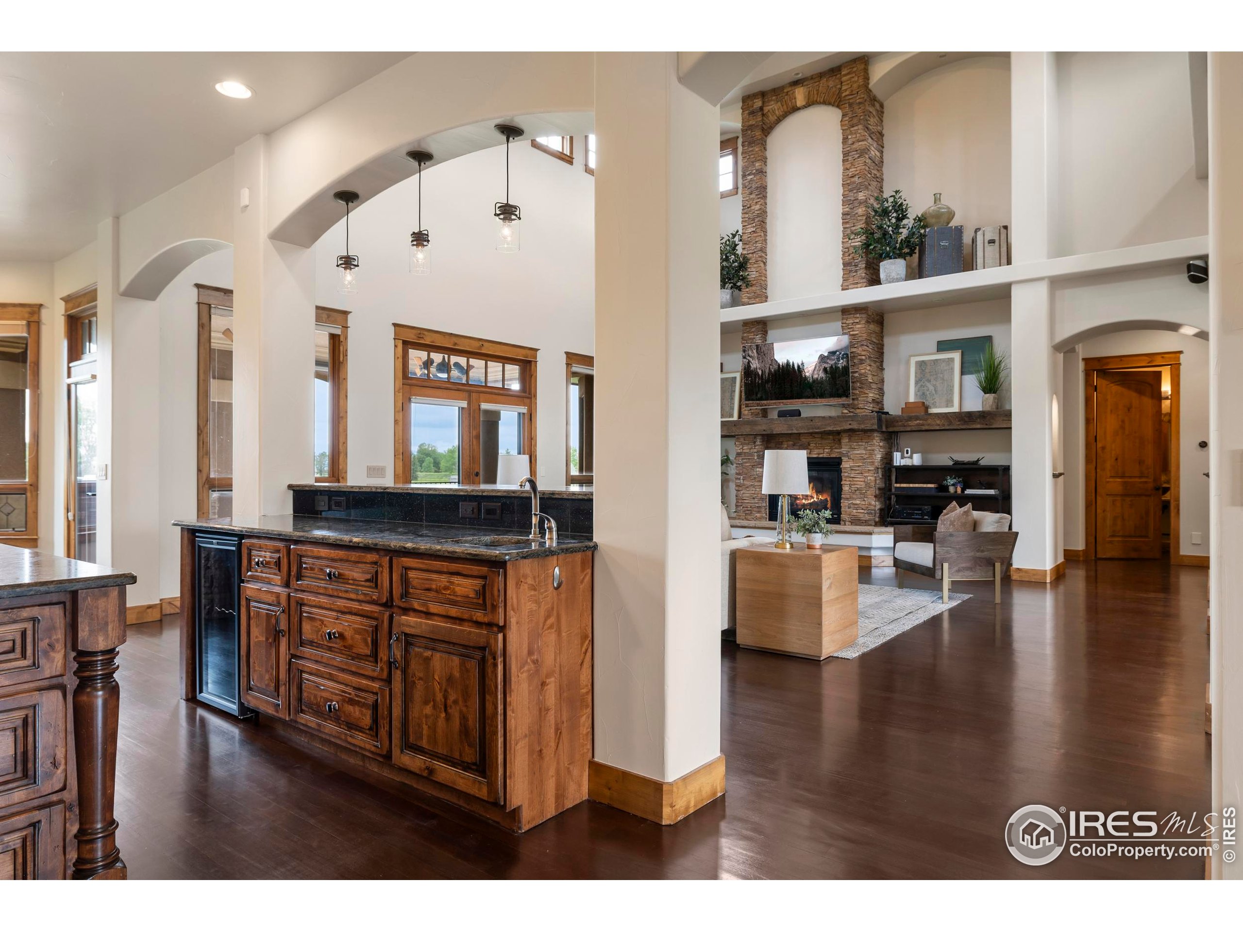 863 Riparian Way Fort Collins, CO 80524 - Photo 9 of 38 a living room with stainless steel appliances kitchen island granite countertop a stove a refrigerator a sink a dining table and chairs with wooden floor