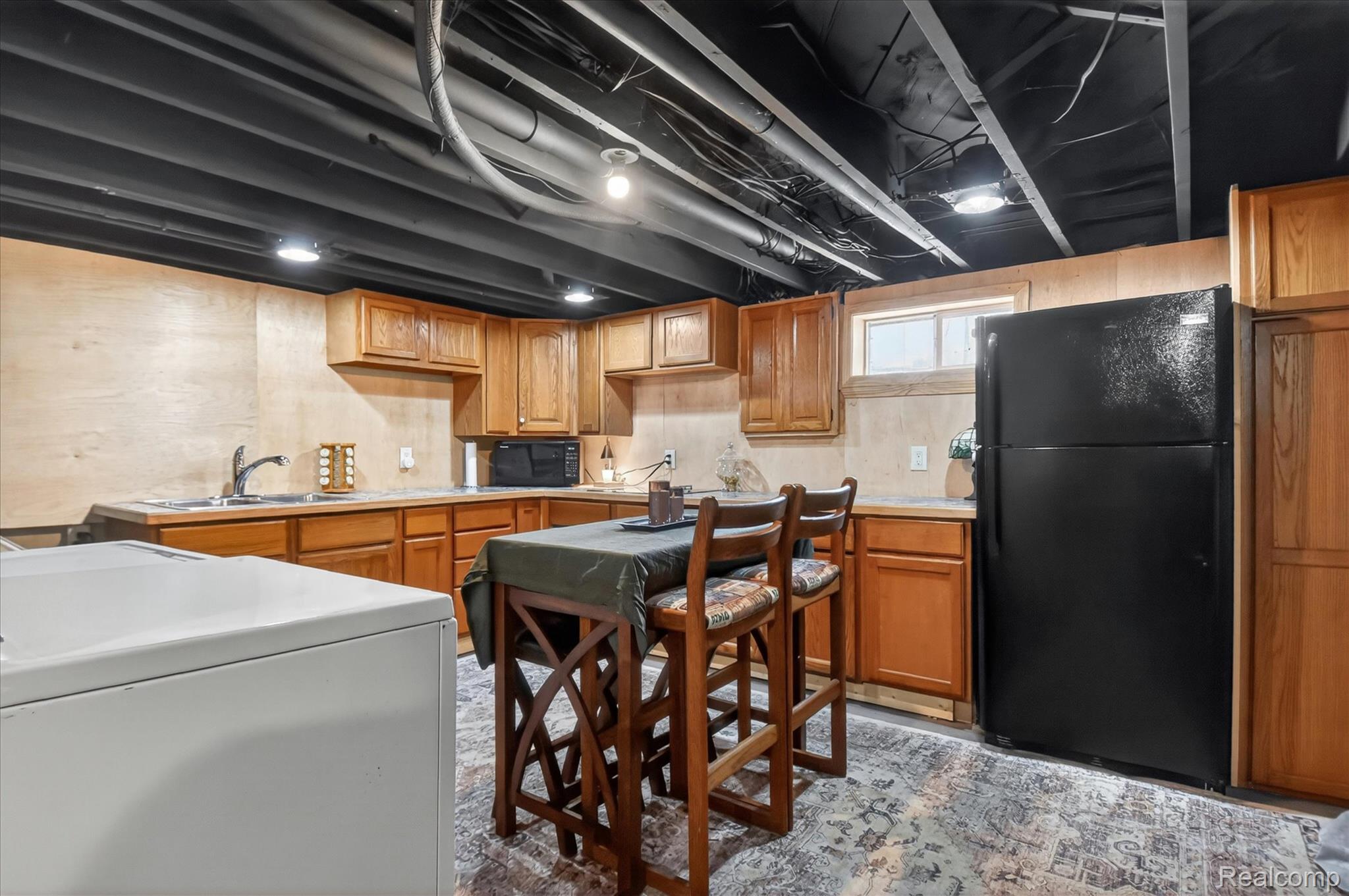 3949 West Burns Line Road Brown City, MI 48416 - Photo 45 of 70 Kitchenette featuring wood-finish cabinetry, a stainless steel sink, and a black refrigerator