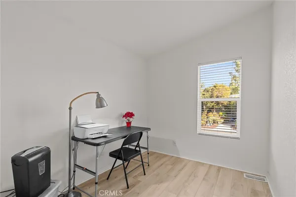 a view of a workspace with furniture and a window