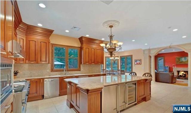 35 Timberline Drive Alpine, NJ 07620 - Photo 17 of 37 a kitchen with stainless steel appliances granite countertop a sink and a wooden floors