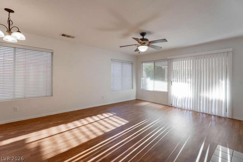 8379 Rockefeller Street Las Vegas, NV 89123 - Photo 6 of 36 Gleaming wood floors anchor a spacious living area flanked by multiple sunlit windows.