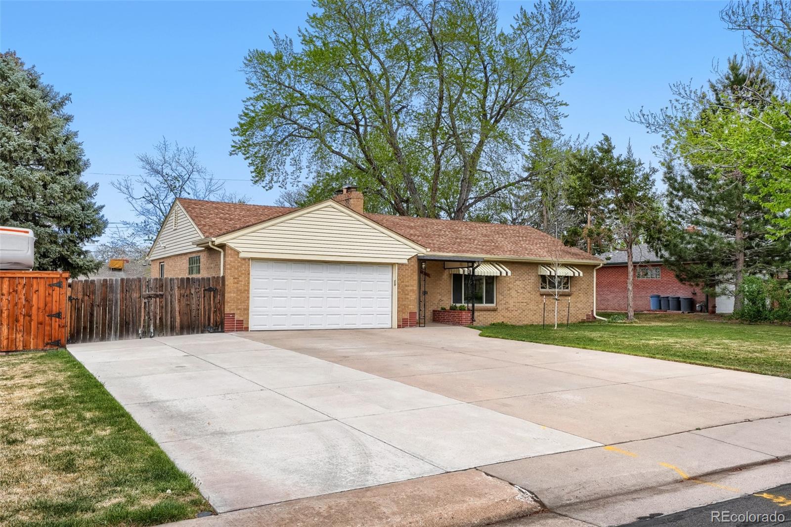 4560 Teller Street Wheat Ridge, CO 80033 - Photo 2 of 25 a front view of a house with a yard and garage