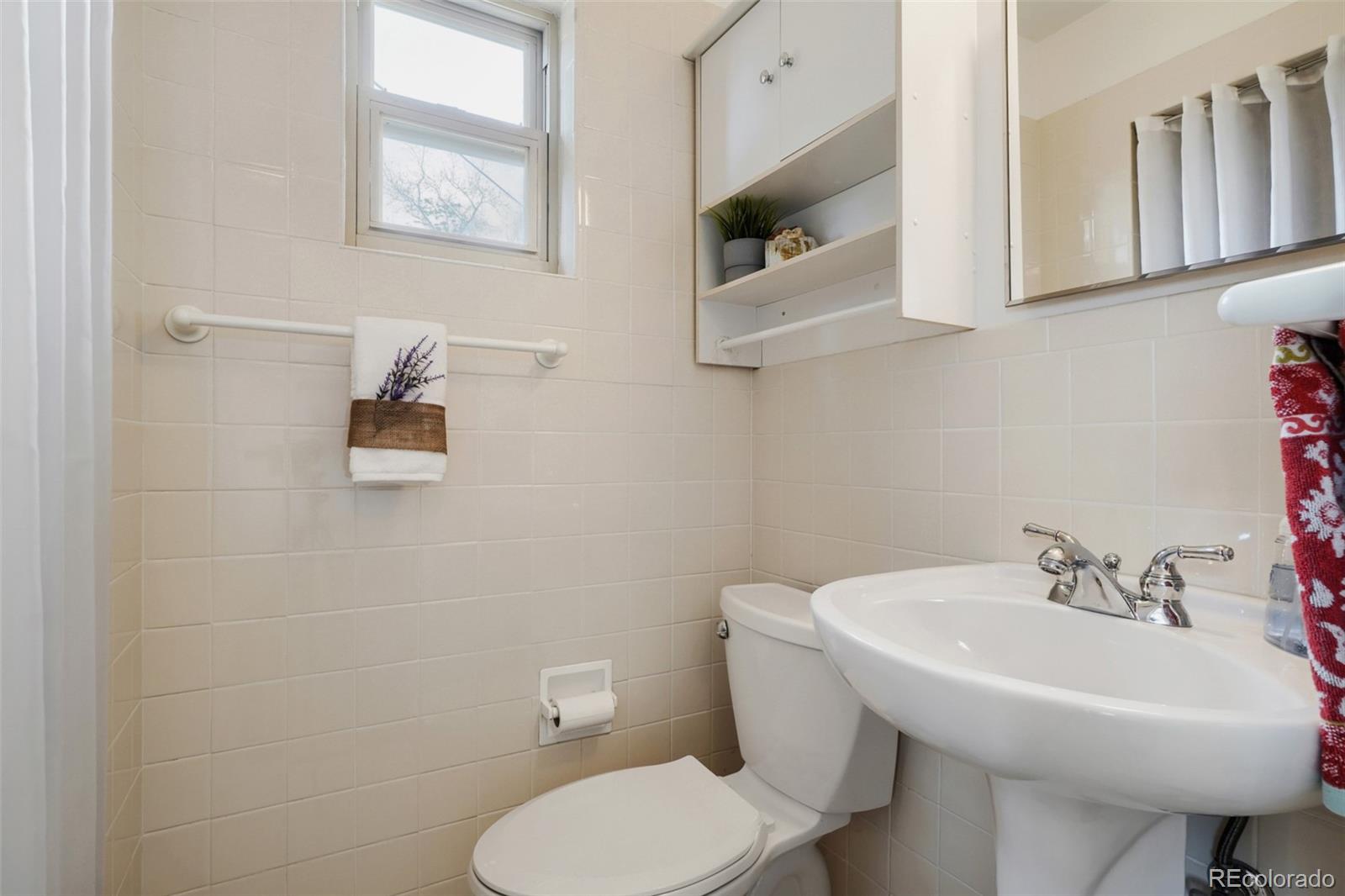 4560 Teller Street Wheat Ridge, CO 80033 - Photo 21 of 25 a bathroom with a toilet a sink and mirror