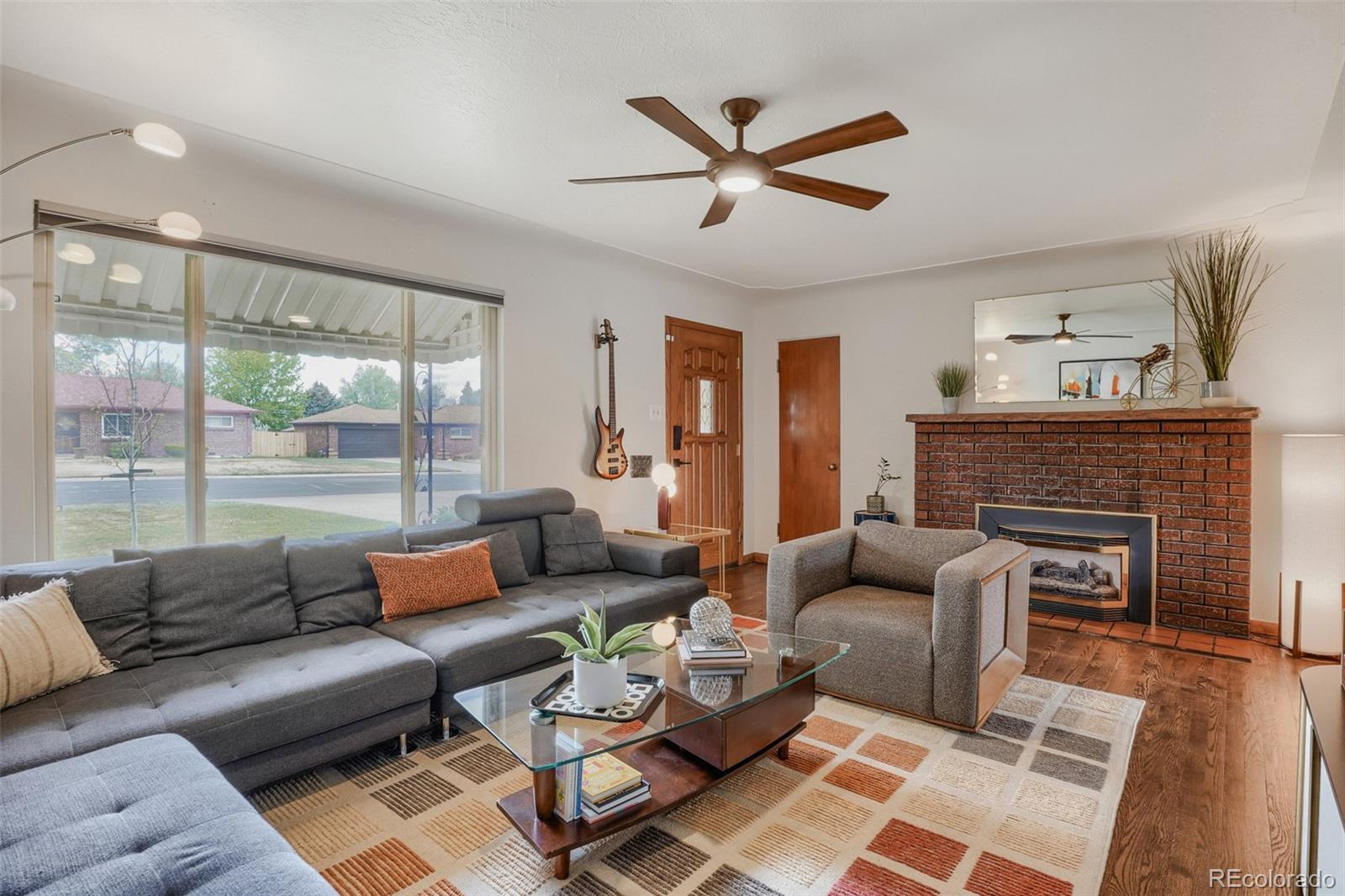 4560 Teller Street Wheat Ridge, CO 80033 - Photo 5 of 25 a living room with furniture a fireplace and a large window