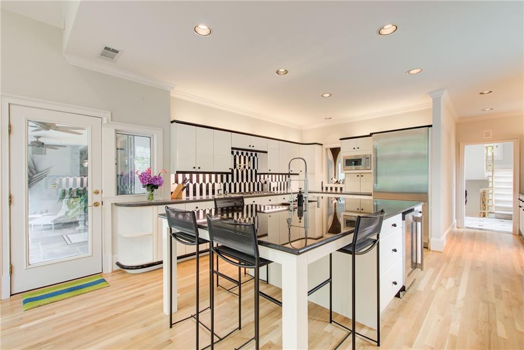 115 Cross Roads Court Atlanta, GA 30327 - Photo 11 of 55 a kitchen with stainless steel appliances kitchen island a table and chairs in it