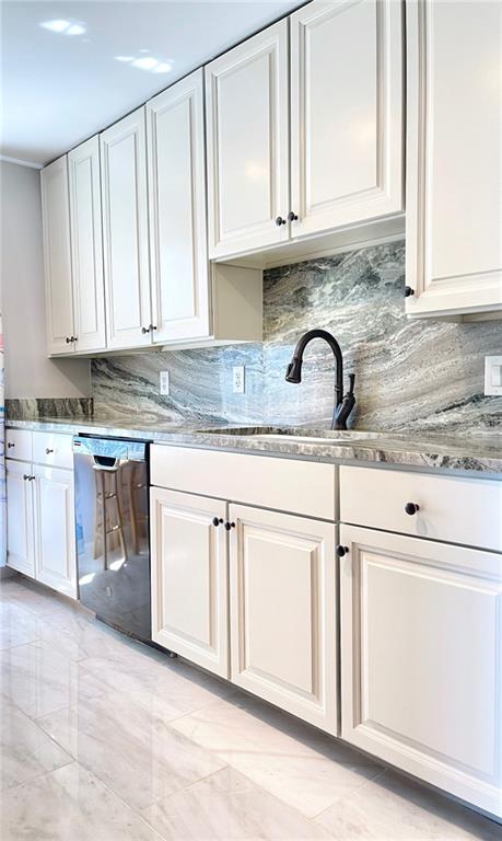 a kitchen with granite countertop white cabinets stainless steel appliances and a sink