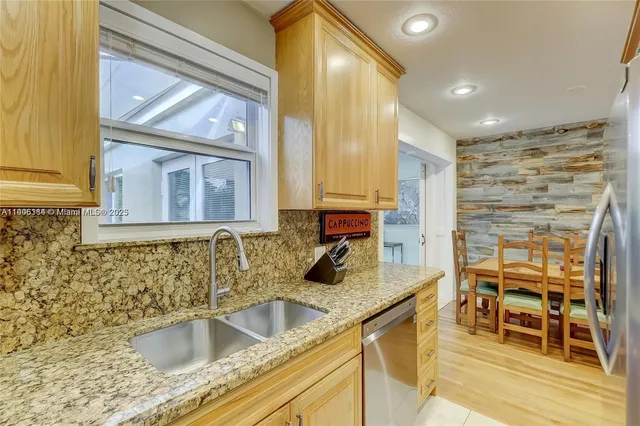 a kitchen with granite countertop a sink and a wooden cabinets