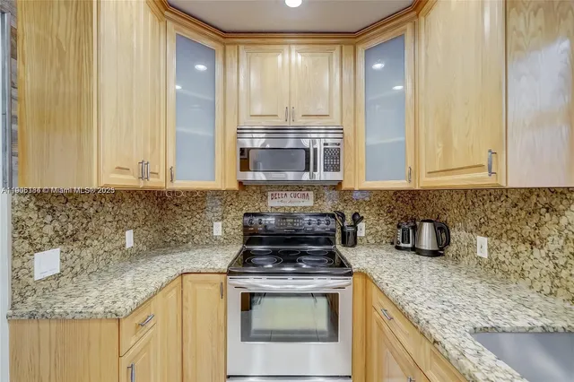 a kitchen with granite countertop stainless steel appliances a stove a sink and a granite counter tops