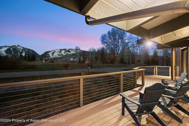 a view of a roof deck with wooden floor and city view
