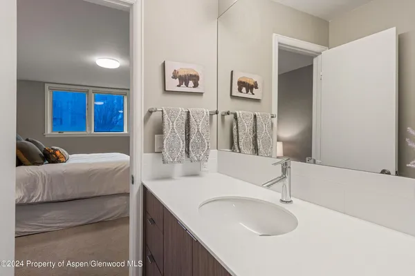 a en suite bathroom with a granite countertop sink and a mirror