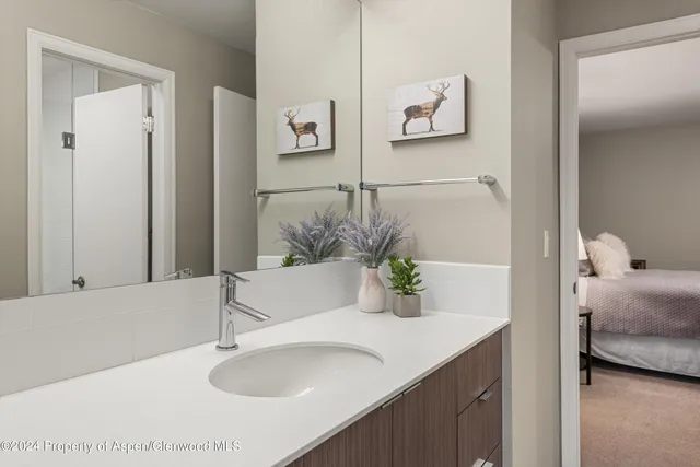 a bath room with a sink and a mirror