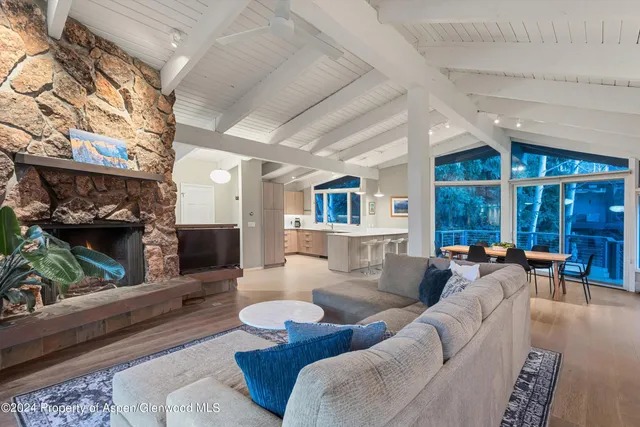 a living room with furniture a fireplace and a floor to ceiling window