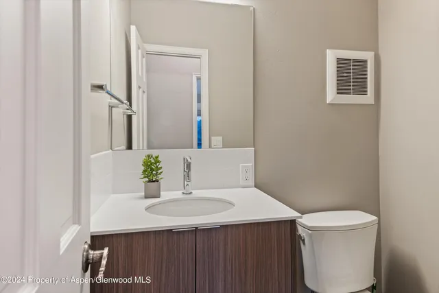 a bathroom with a sink a toilet and a mirror