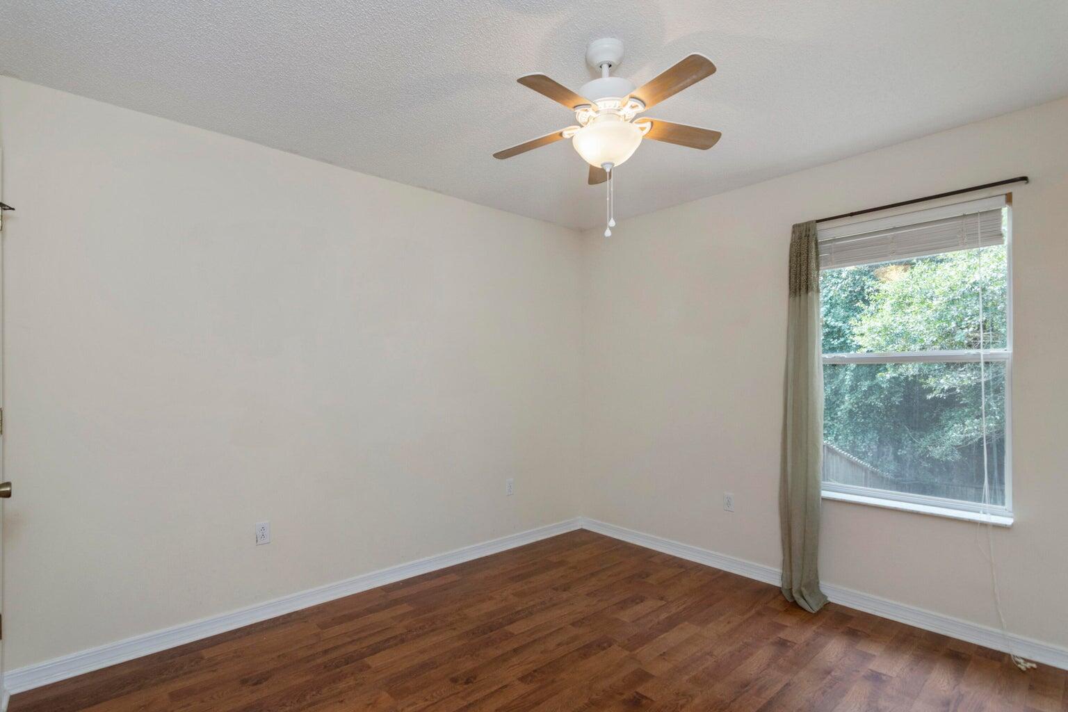 168 Cabana Way Crestview, FL 32536 - Photo 21 of 29 an empty room with wooden floor and windows