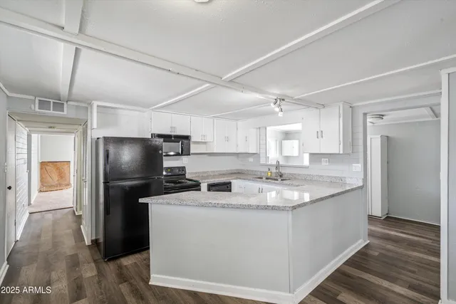 a kitchen with stainless steel appliances granite countertop a refrigerator a sink a stove and a refrigerator