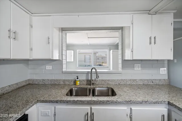 a kitchen with granite countertop a sink and cabinets