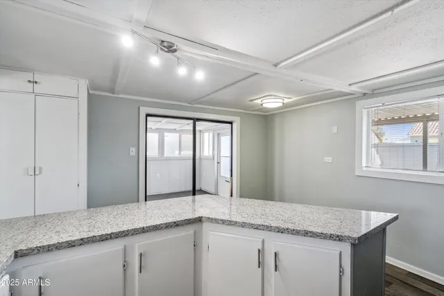 a hallway with granite countertop white cabinets and a granite counter top