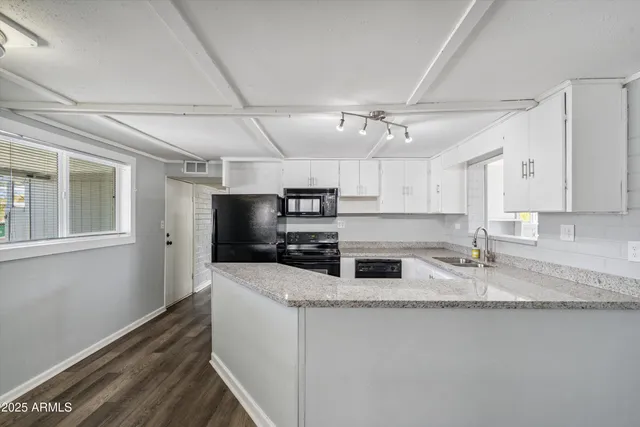 a kitchen with stainless steel appliances granite countertop a sink a stove and a refrigerator