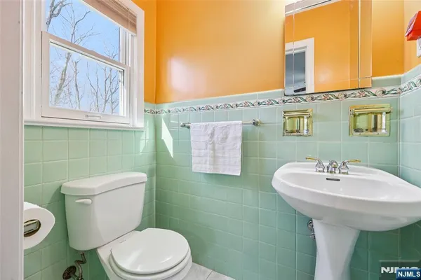 a bathroom with a sink toilet and mirror